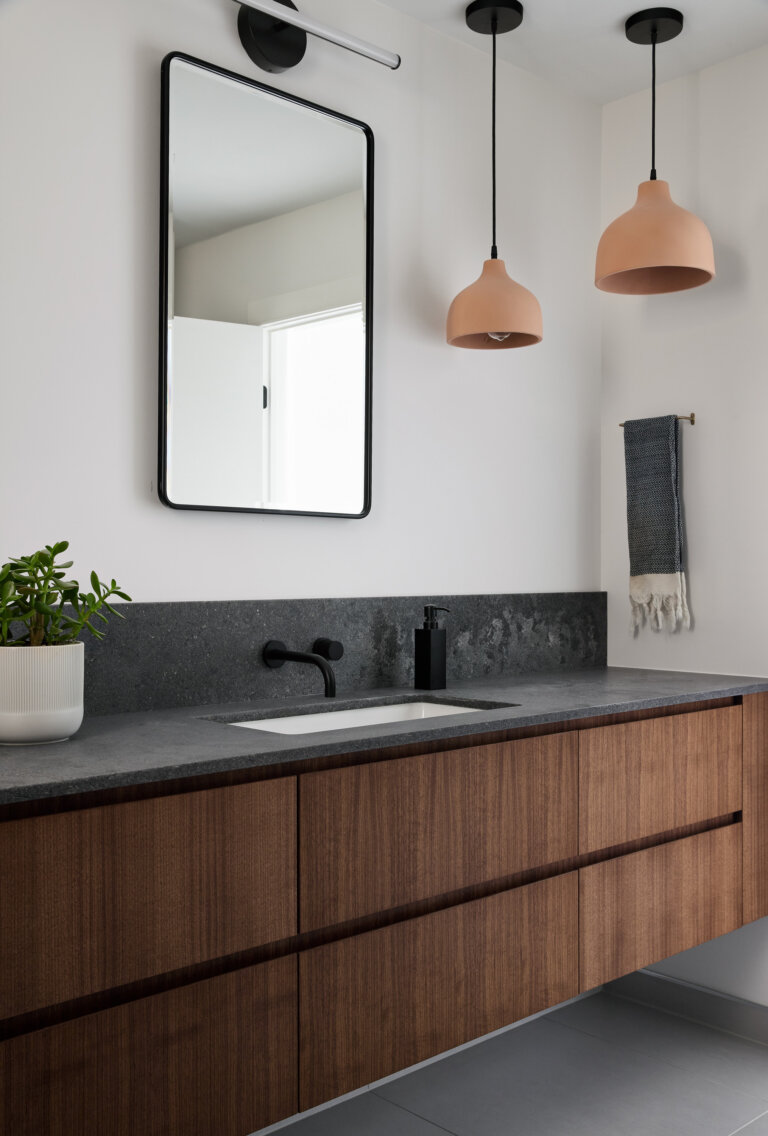 Modern bathroom vanity with walnut base and dark quartz top